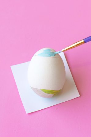 Someone painting an egg