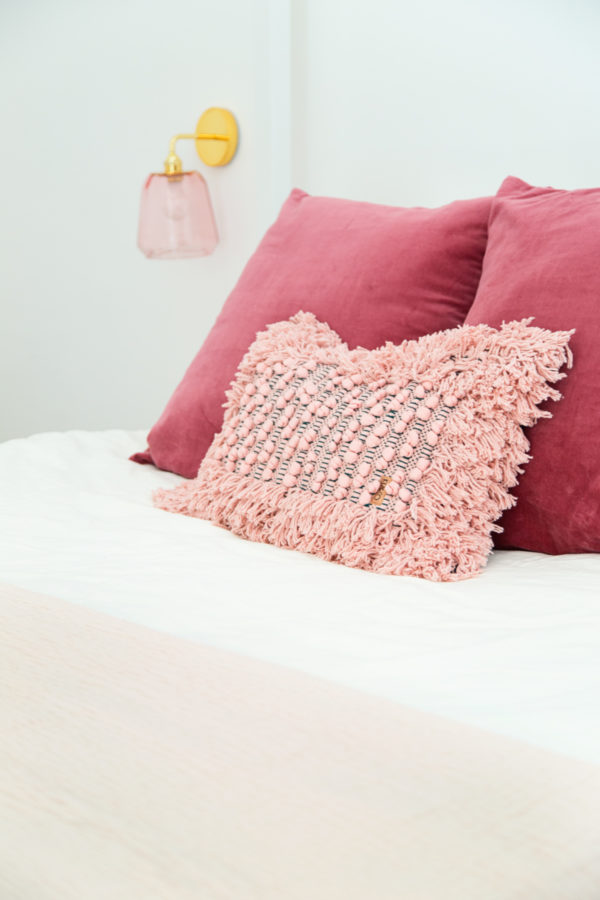 A pink pillow on a bed