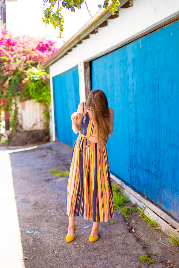 A person standing in front of a blue building