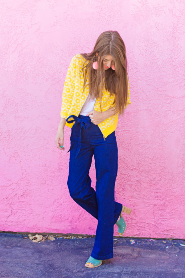 A person standing in front of a pink building