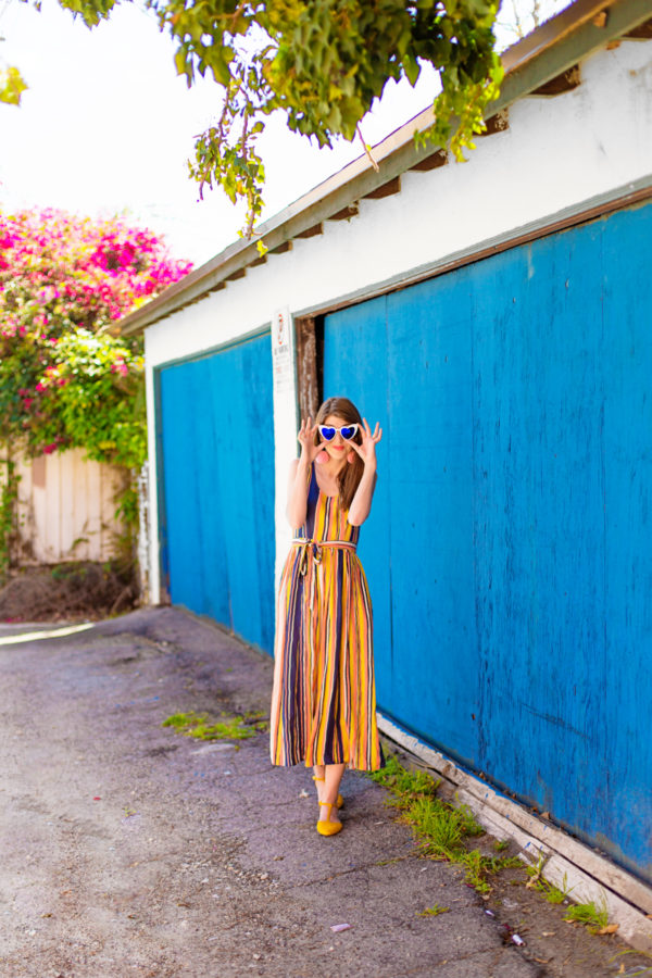 A person standing in front of a blue building