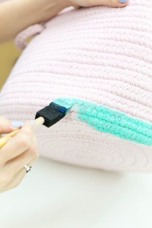 Someone painting a basket turquoise
