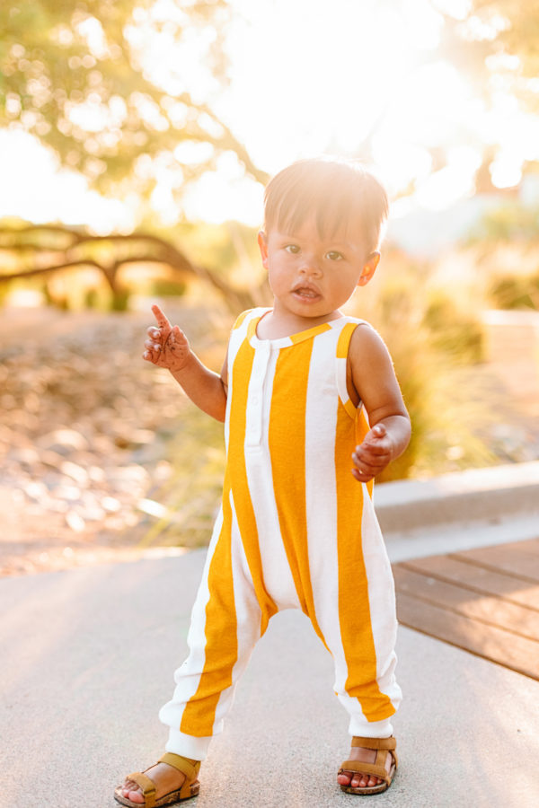 A little boy wearing a yellow jumpsuit