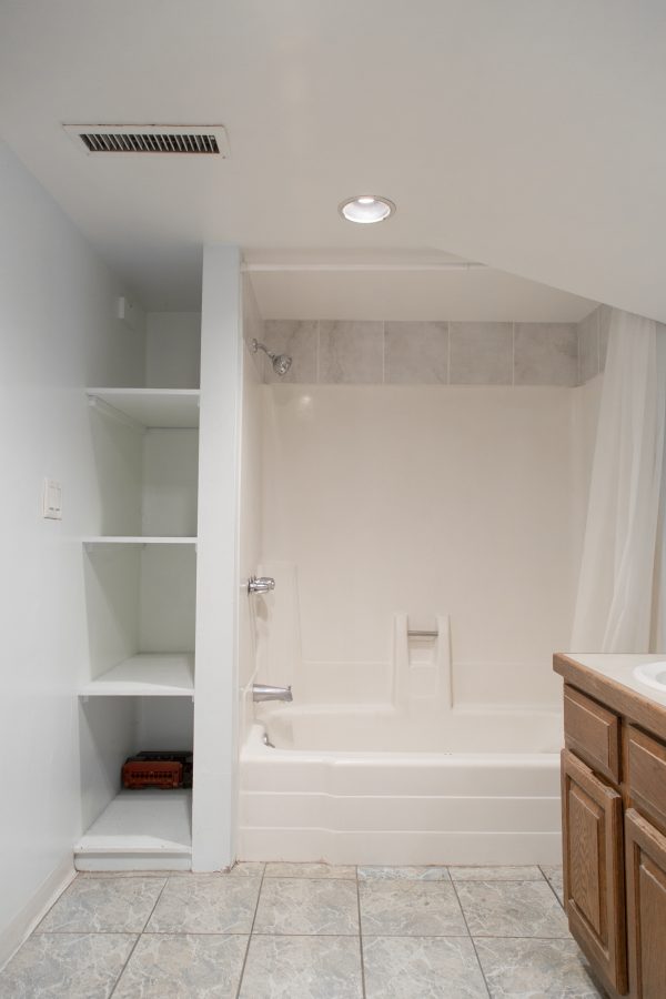 A room with a shower and shelves