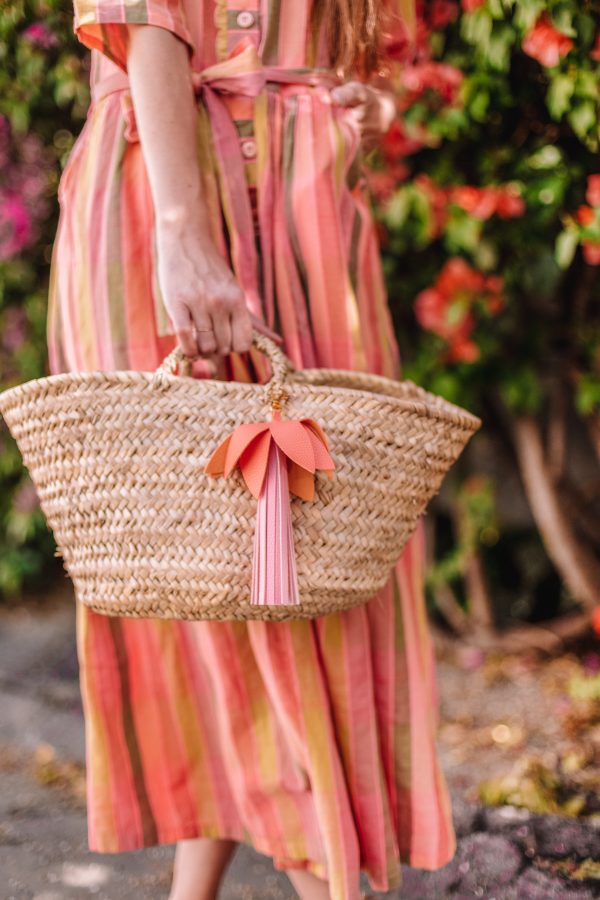 A woman wearing a pink dress holding a basket