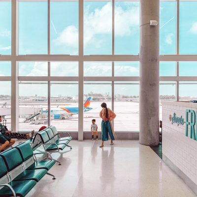 How To Survive Flying With A Baby or Toddler (Our Tips, Gear and Favorite Activities for the Plane!) Two people in an airport