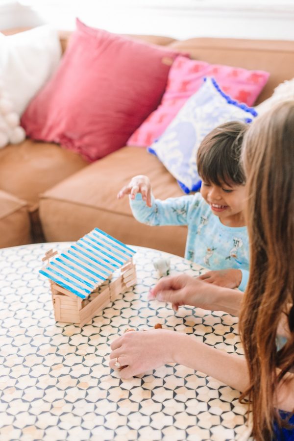 A small child playing with popsicle sticks