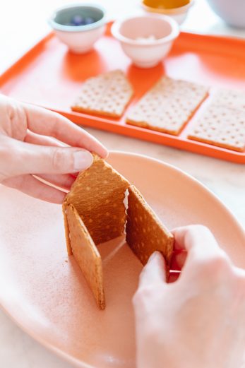 Someone making a house with graham crackers