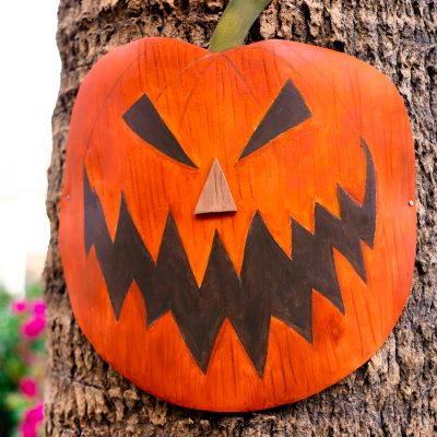 A pumpkin decoration on a palm tree