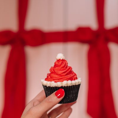 Easy Santa Hat Cupcake Recipe A person holding a Santa hat cupcake