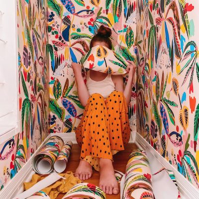 How To Make Regular Wallpaper Removable A women in a closet with colorful wallpaper