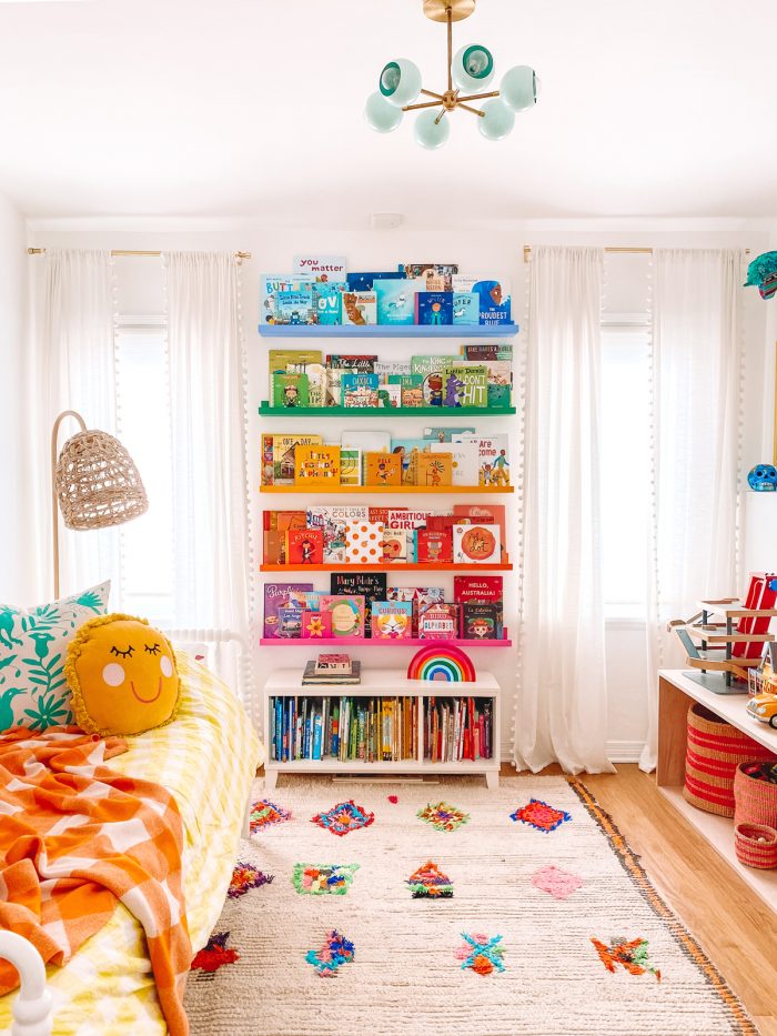 A bedroom with rainbow shelves
