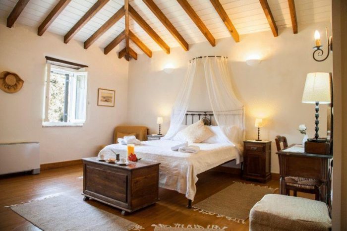 A bedroom with a bed and ceiling with beams
