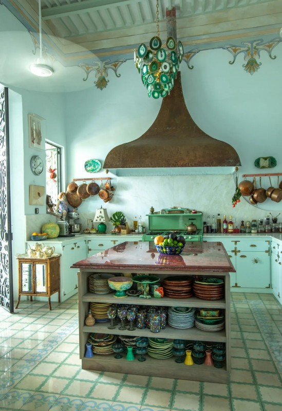 A mint blue kitchen with large kitchen hood