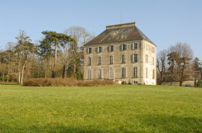 A large building with a grassy field