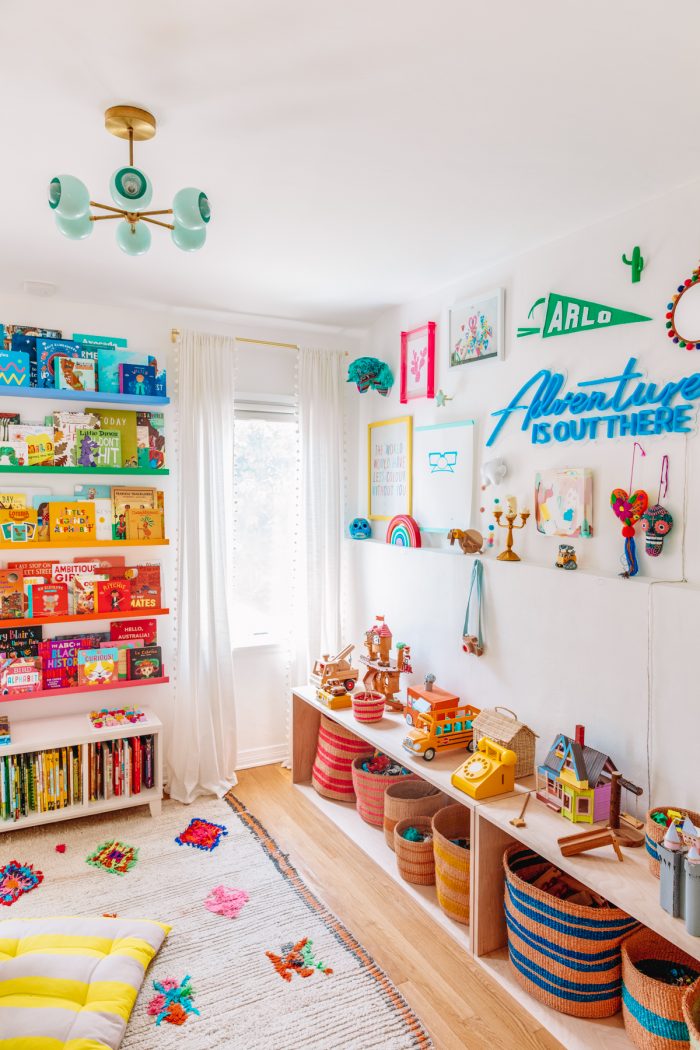 A bedroom with toys and bookshelves