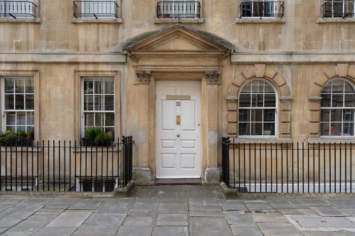 A white exterior door in a beige building