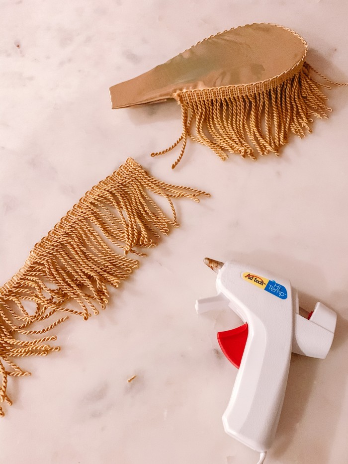 Gold fringe on gold epaulettes with a note glue gun on marble table