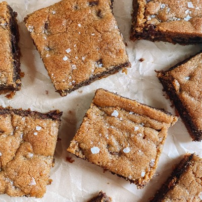 Easy Chocolate Chip Cookie Bars chocolate chip cookie bars on parchment paper with flaked salt on top