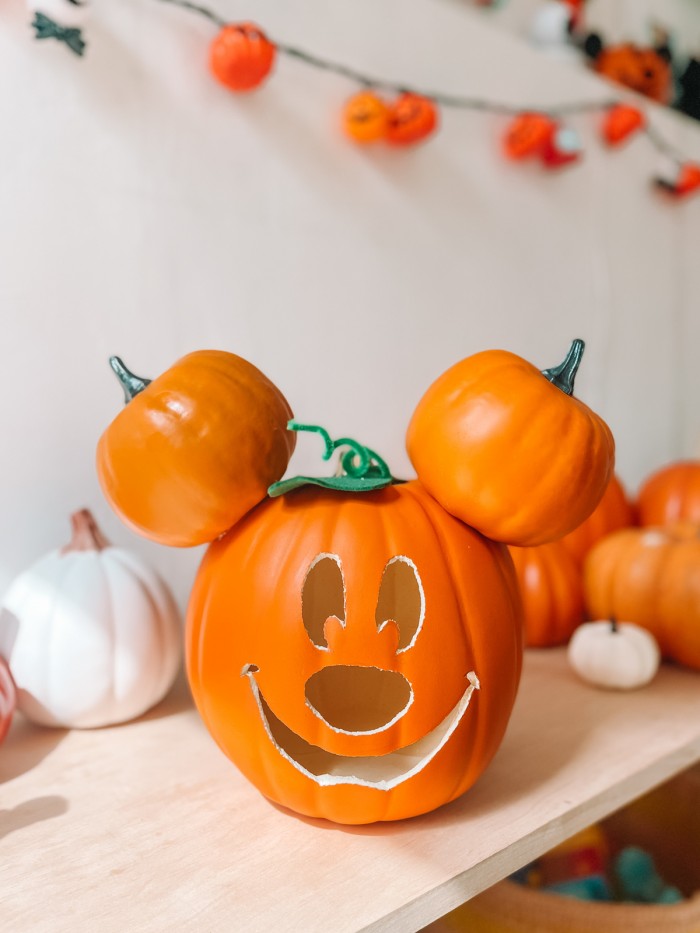 Mickey Pumpkin on shelf in front of pumpkins and white wall