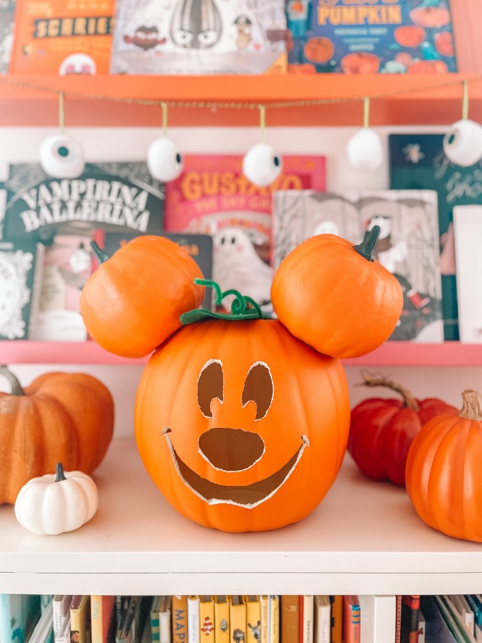 Mickey pumpkin in front of Halloween books and eye ball garland