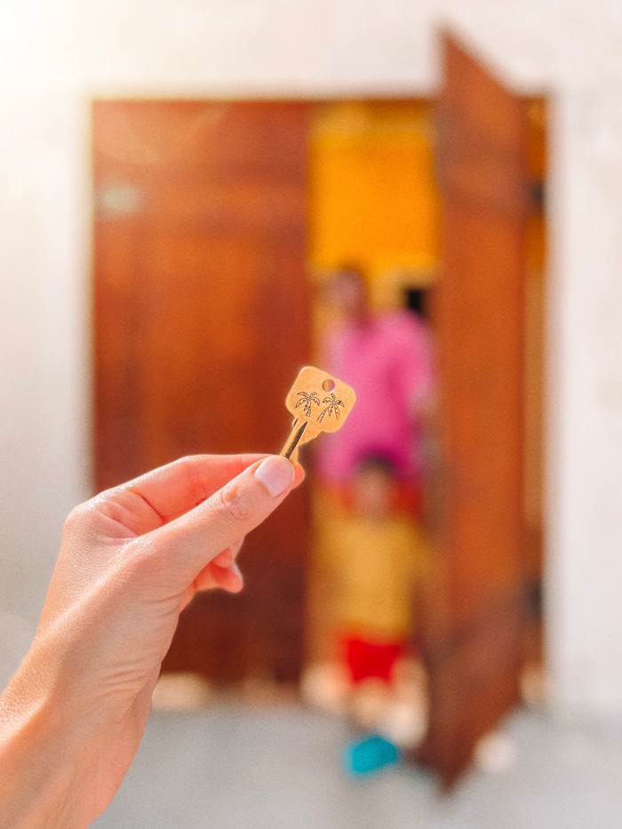Key held up in front of wooden doors
