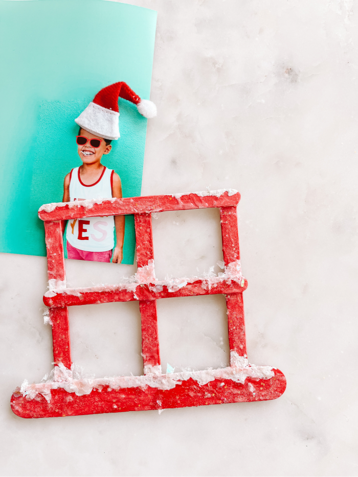 Popsicle stick window with fake snow and photo of child