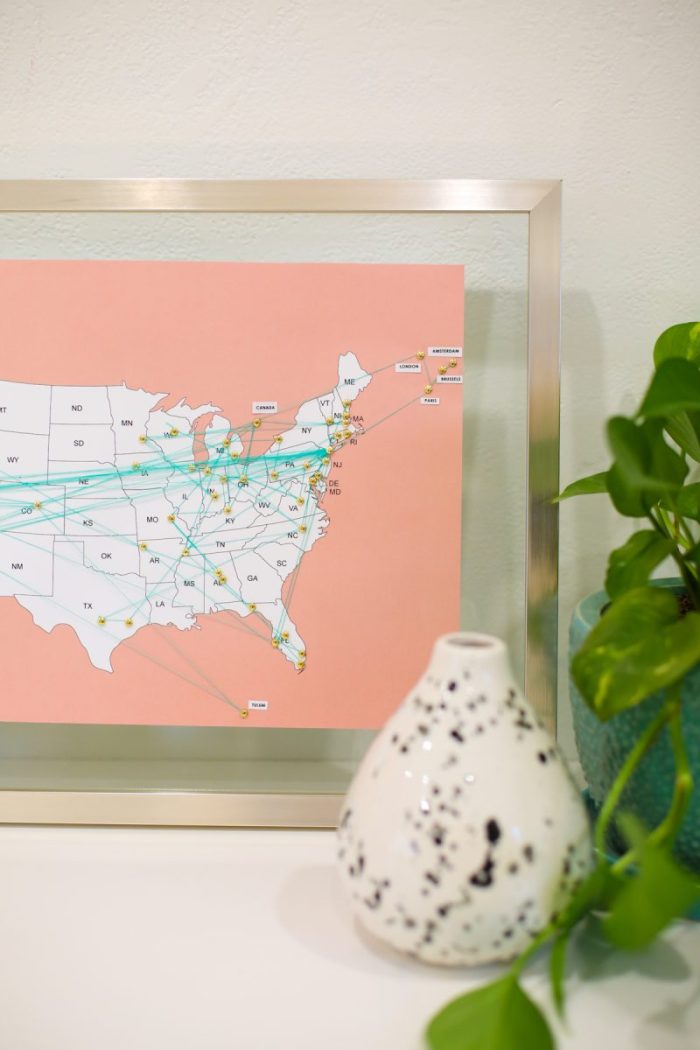 Map of the USA in a frame with pins and yarn on it.