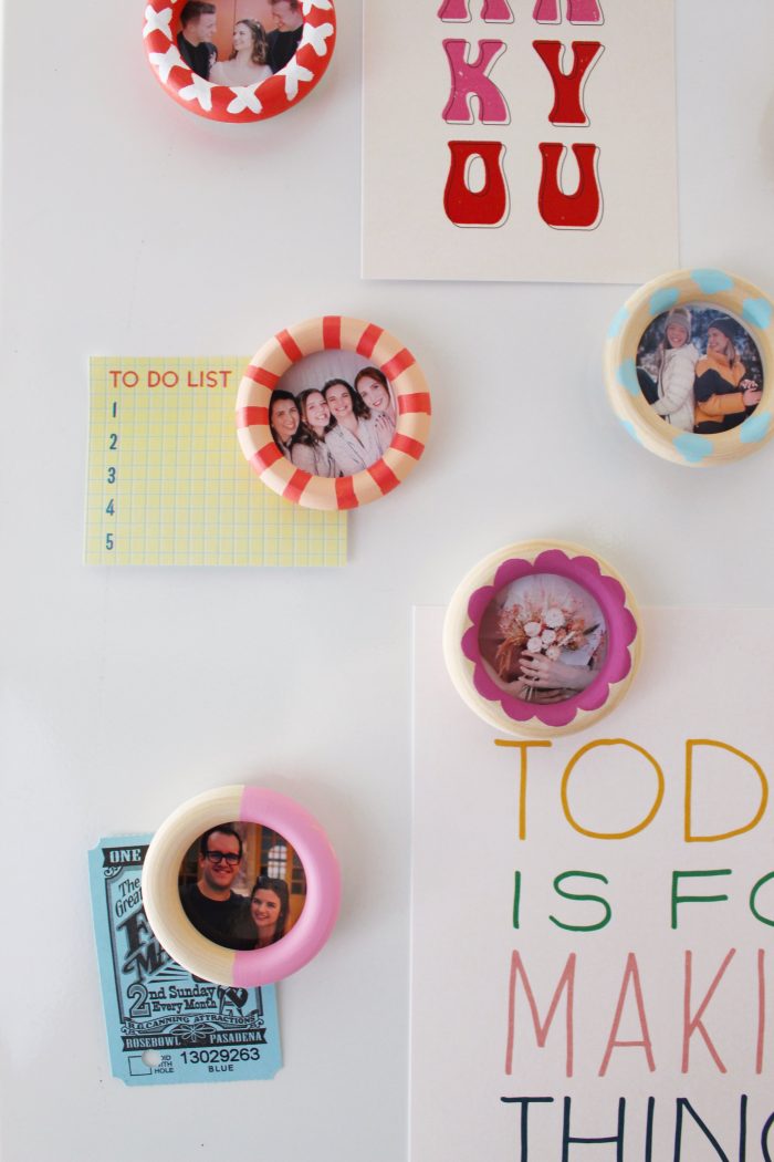 Hand painted frame magnets that are stuck to a fridge.