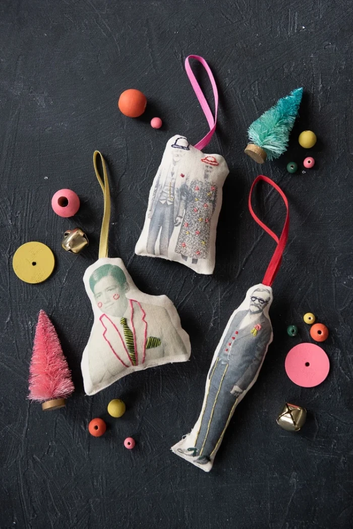 Plush photo ornaments on a black background with craft supplies around them.