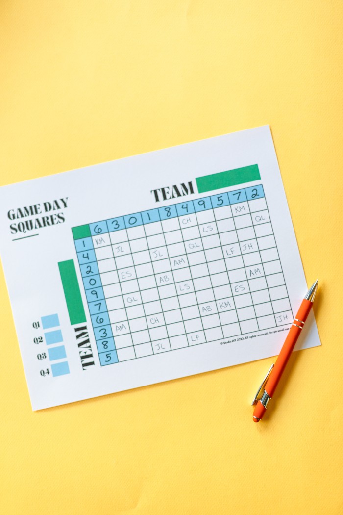 Football Game Squares Football Game Squares printed and placed on a yellow surface with a pen.