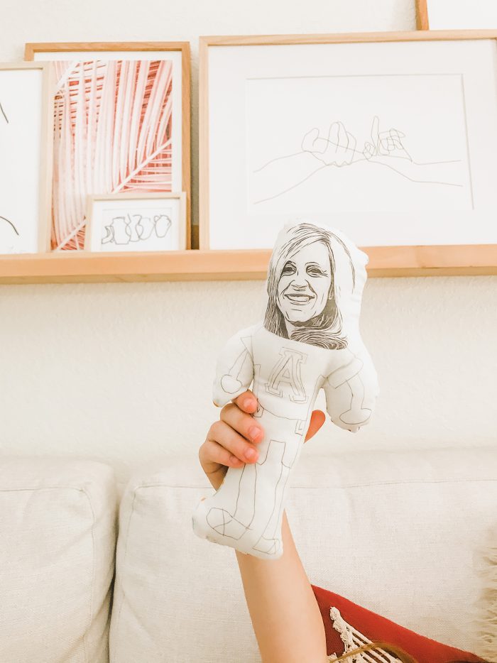Hand holding a plush homemade doll up in the air.