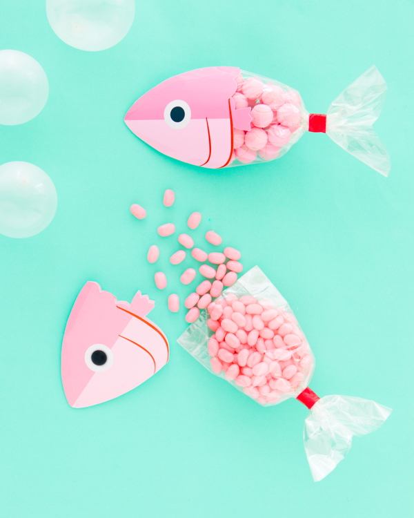 Fish party favor bag on a table filled with candy.
