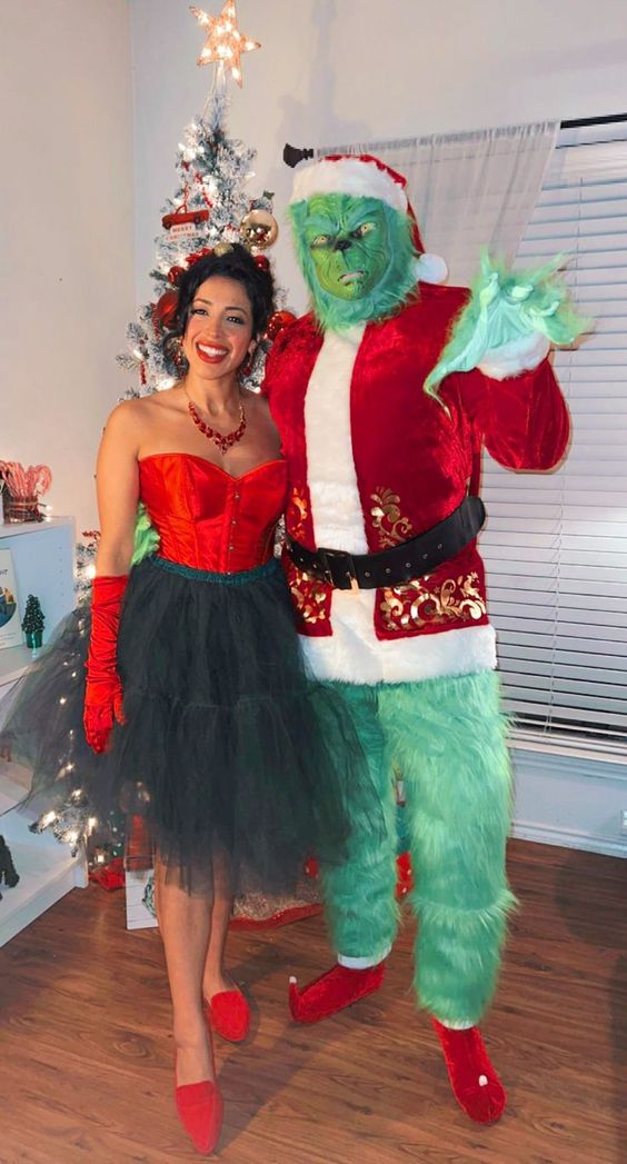 The Grinch Christmas Costumes Two people dressed up as the Grinch and Martha May standing in front of a Christmas tree.
