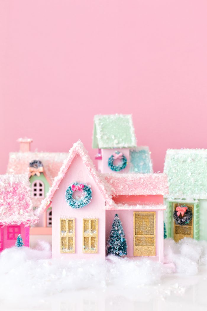 Easy Christmas Bucket List Ideas Small Christmas village with a pink background.