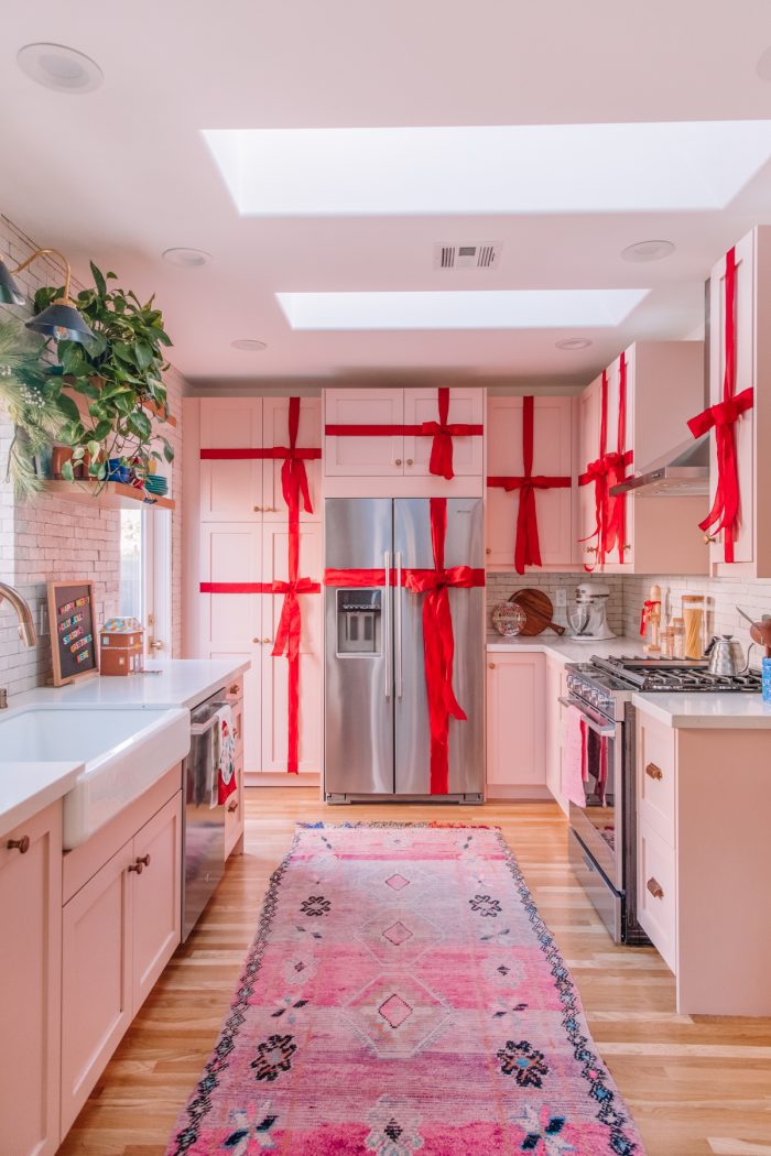 Festive Holiday Bucket List Kitchen with cabinets wrapped in red ribbon to look like presents.