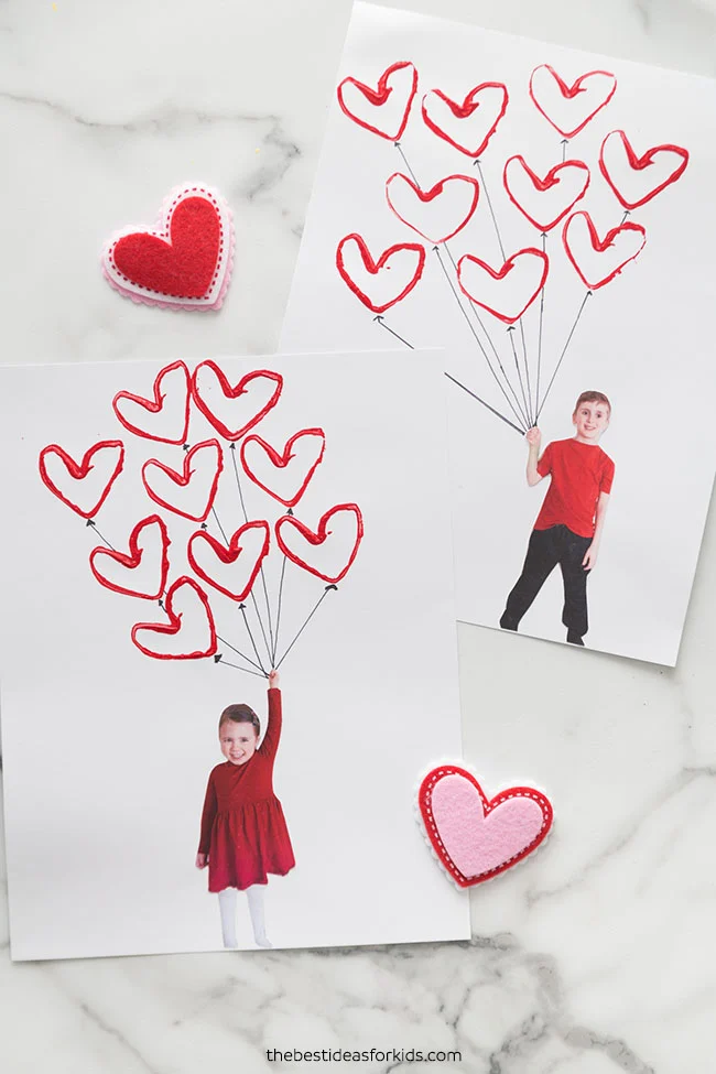 Valentine Balloon Craft Two pieces of paper each with a photo of a child holding heart-shaped balloons.