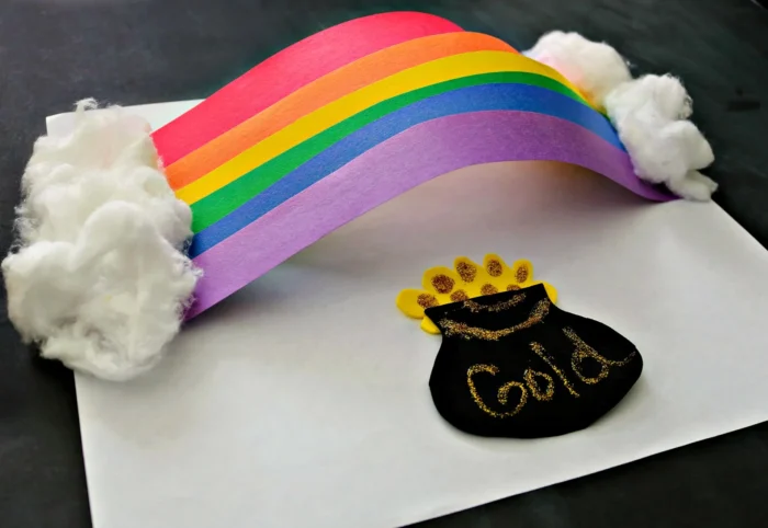 3D rainbow made out of construction paper with a pot of gold underneath it. 