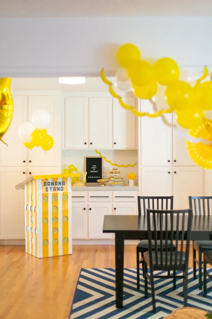 Banana Party Banana themed party with yellow balloons and a banana stand.