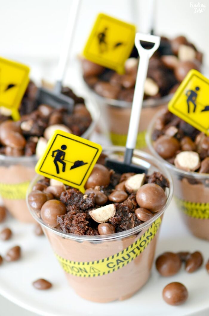 Construction-Themed Party Chocolate dessert cups that have construction tape, signs and a little shovel as a spoon.
