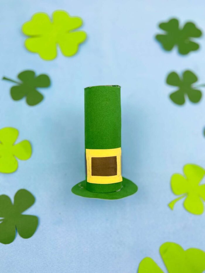Leprechaun hat surrounded by shamrocks. 