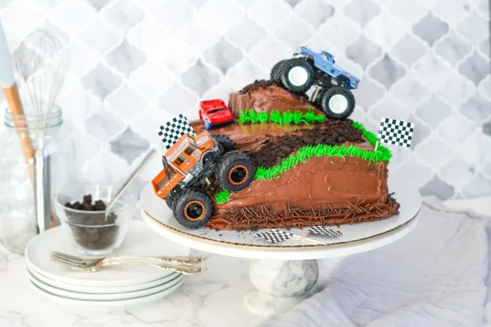 Monster Truck Cake Chocolate cake with two monster trucks on it.