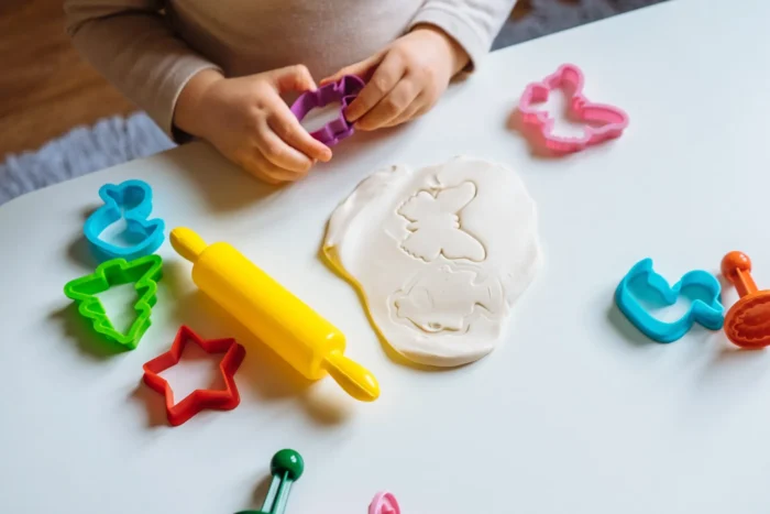 Play Dough Party Playdough rolled out next to cookie cutouts.