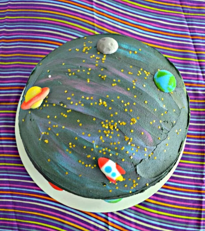 Space Party Black cake made to look like space with small planet figures.
