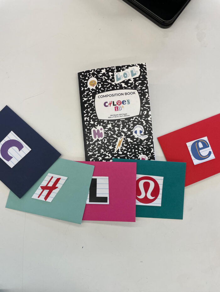 Scavenger Hunt Party Notebook next to pieces of paper with logos on them.