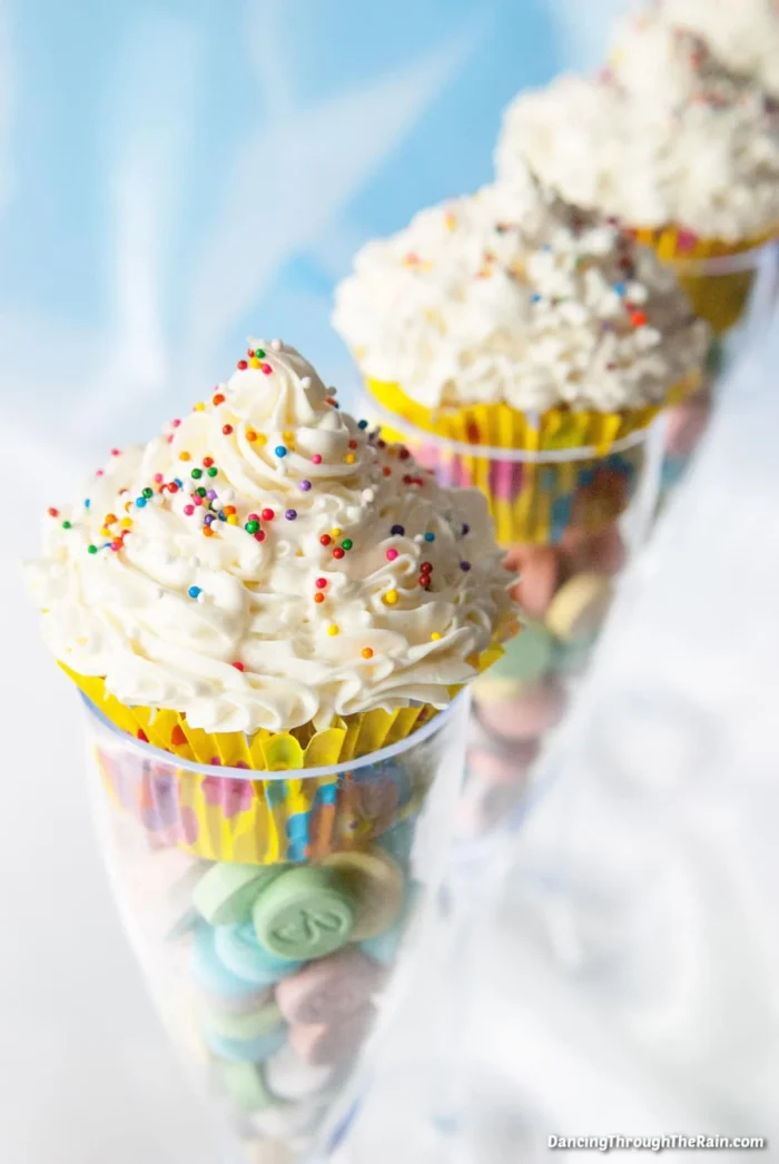 Birthday Gala Party Champagne glasses with candies in the bottom and cupcakes on top.