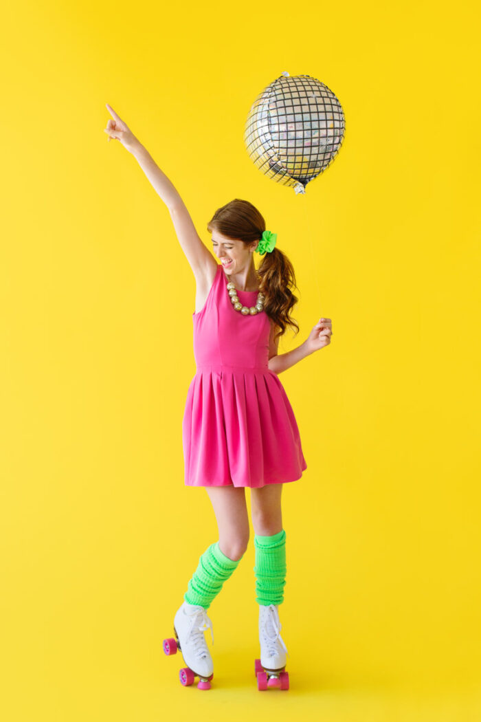 Rollerskating Party Woman standing with a disco balloon and roller skates on.
