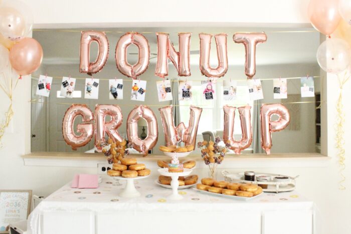 Donut Grow Up Party Table with donuts and balloons that say "donut grow up".