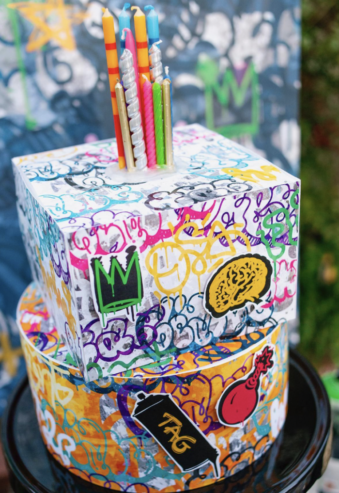 Graffiti Party Two boxes covered in graffiti stacked on top of each other with birthday candles on top.