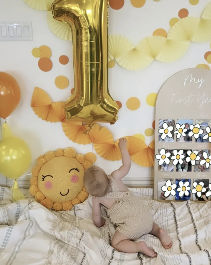 You are my Sunshine Birthday Large "1" balloon with yellow decorations and a baby looking up at it.